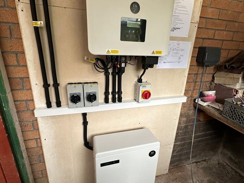 SolaX inverter and 5.2kWh home battery mounted on a garage wall in Llanelli by EJS Electrical and Renewables